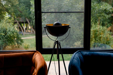 Interior with orange and blue leather chairs and a wooden table by the window. Modern furniture decoration.の写真素材
