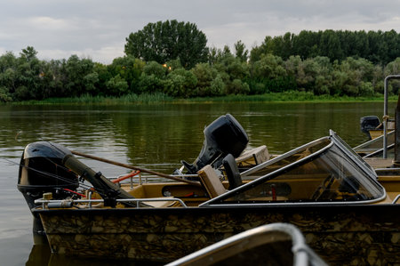 Several motor boats are moored to a wooden pier. boats on a pier by the riverの写真素材