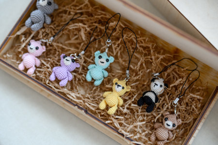 Amigurumi toy Set: knitted bears on strings in a wooden box. Cute souvenirs: knitted key rings in...