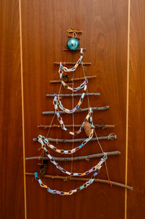 A DIY Christmas tree made from branches, paper garlands, and pine cones. Christmas decor made from...