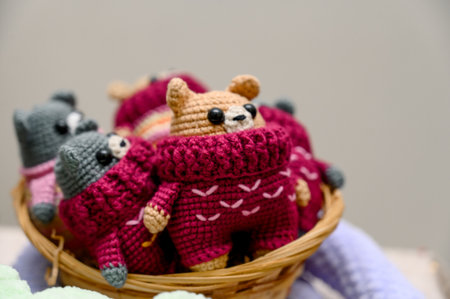 Several crochet teddy bears in cozy sweaters. A wicker basket filled with knitted bears in burgundy sweaters. A festive winter souvenir.の写真素材