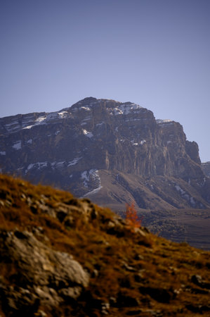 Panorama of the Caucasus Mountains. Rocks and mountain terraces above the meadow. Autumn landscape:...