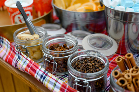 Jars with spices and additives for hot drinks: cloves, star anise, cinnamon and ginger. A set of...