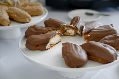 Bouche or cakes in milk chocolate on a white round buffet stand. A white stand full of chocolate...
