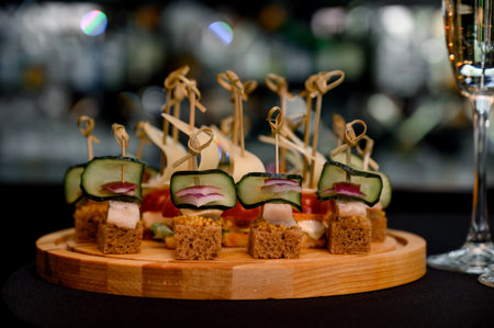 Canapes with rye bread, fish, cucumber, red onion and mustard on a wooden board. Set of canapes...