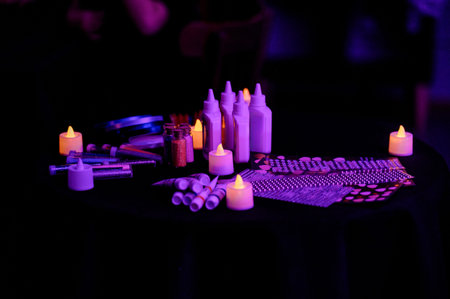 Various craft supplies including glue bottles, glitter, and decorative items arranged on a table...