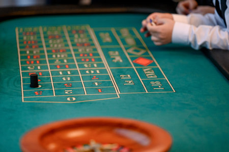Close-up of a roulette table showing chips and a dealer's hands placing bets in a vibrant casino...