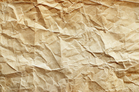 A close-up shot of a piece of crumpled, aged, beige paper.の素材