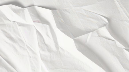 A close-up image showcases the abstract texture of white creased fabric, highlighting its folds and subtle shadows.の素材