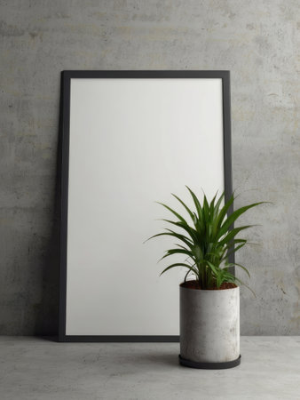 A minimalist scene featuring a blank black frame and a potted plant against a textured concrete wall.の素材