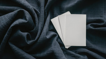 Blank white business cards on dark fabric background. Mockup for branding identity.の素材