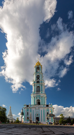 Bell tower of orthodox church under a large white cloudの写真素材