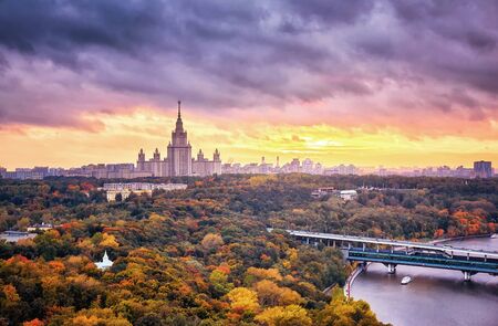 Rainy sunset clouds above river, park, bridge, ships and large city landscape of autumn Moscowの写真素材