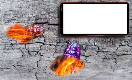 Conceptual view of computer bug attack on cell phone with blank white screen on cracked wooden desk backgroundの写真素材
