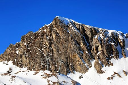 Aerial view of sunny Alp summits and blue mountain range in winter Austria