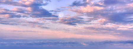 Dramatic sunset clouds and full Moon in evening sky