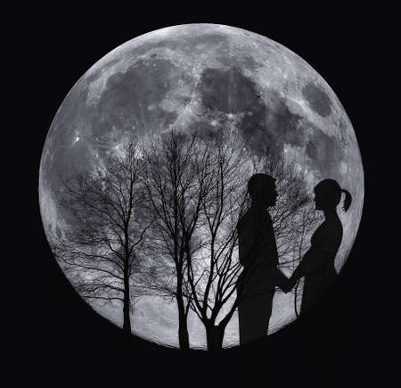 Dark silhouettes of love couple in full Moon nightの写真素材