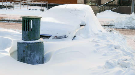 Snow covered car in Moscow streets in sunny winter streetの写真素材