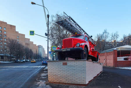 Moscow, Russia - March 30 2021: Monument with red fire rescue retro car on sunsetの写真素材