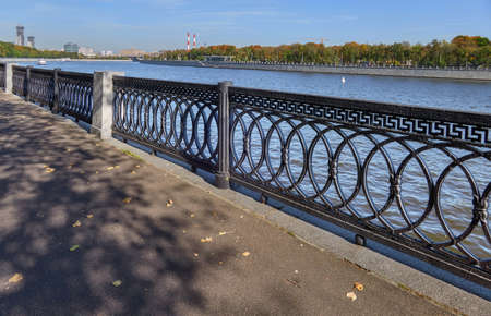 Riverbank fences and asphalt road in autumn Moscowの写真素材