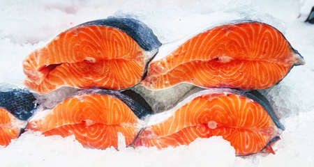 Red salmon pieces in ice on sale in marketの写真素材