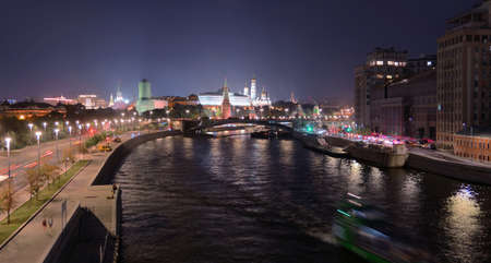 Moscow, Russia - August 1st 2021: Illuminated Moscow river tonight with nice reflections and historical buildings with Kremlin, Red wall and bridge under constructionのeditorial素材