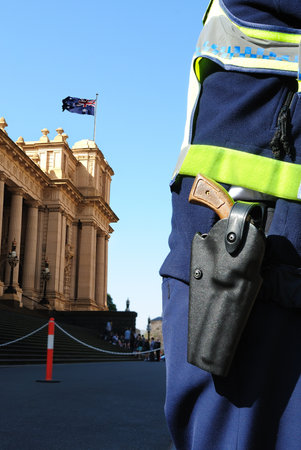 Protective services officer standing in front of the Parliament House in Melbourneのeditorial素材