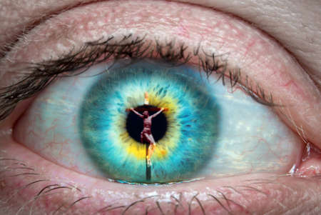 Close up of eye with Jesus Christ on the cross reflected in it