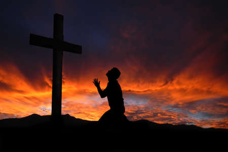 Dramatic sky scenery with a mountain cross and a worshiperの写真素材