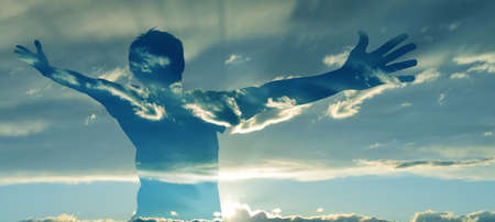 Double exposure image of man silhouette with wide open armsの写真素材