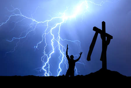 Dramatic sky scenery with a mountain cross and a worshiperの写真素材