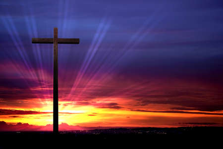 Cross silhouette over red dramatic sky at sunset