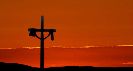 Clouds and sunbeams shining on a cross for Easter morningの写真素材