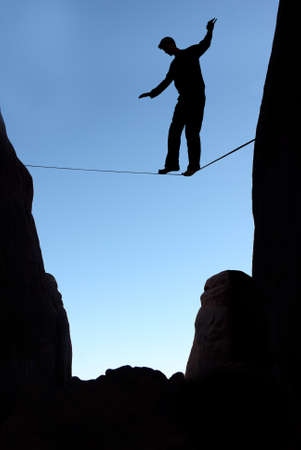 Silhouette of man on the rope concept of risk taking vertical imageの写真素材