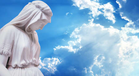 Statue of the mother of Jesus Christ over blue sky background panoramic viewの写真素材
