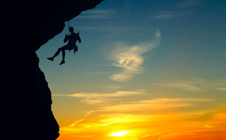 Silhouette of a climber over beautiful sunsetの写真素材