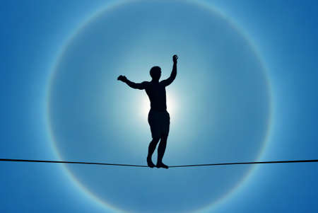 Silhouette of man balancing on the rope concept of risk taking 
