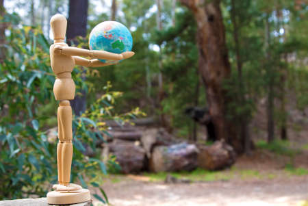 Eearth globe in hands of wooden doll wildlife and environment protection conceptの写真素材