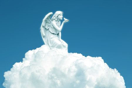 Angel on white cloud against blue clear sky with copy spaceの写真素材