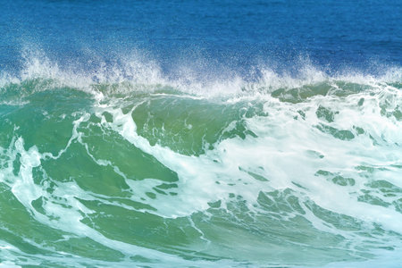 Turquoise colored waves crashing the seashoreの写真素材