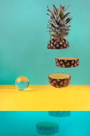 Pieces of pineapple in the air and crystal ballの写真素材