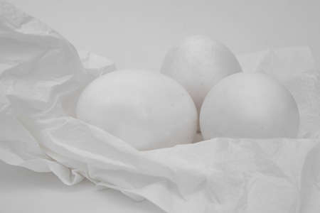 White eggs on a crushed white napkin, white backgroundの写真素材