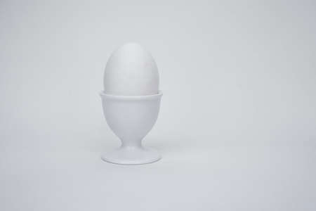 White egg on a white background, with a cupの写真素材