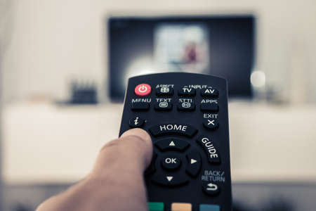 Watching television and using remote controlの写真素材