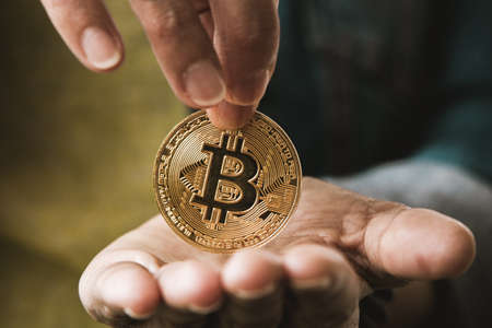 Bit coin coin in a woman's hands