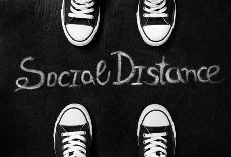 Social distance, Legs of people distant, sneakers on a red background, separated by a virus, illustrationの写真素材