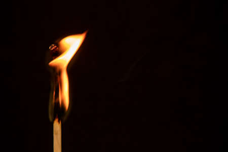 Burning match on a black background
