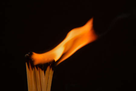 Burning match on a black background