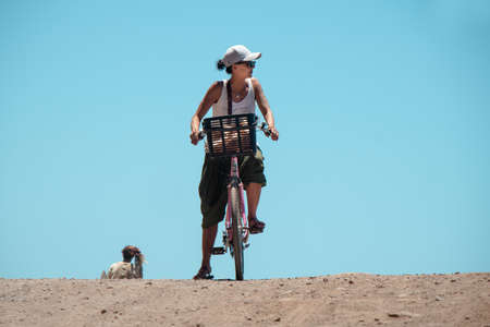 A girl on a bicycle on her way to a rock, La Gomeraの写真素材