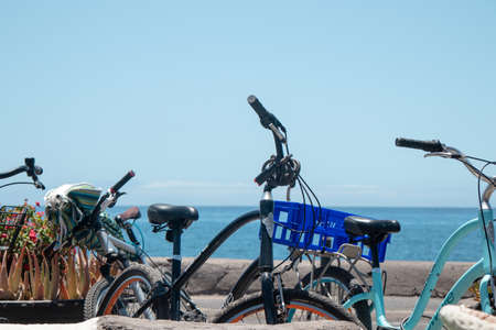Stopped bicycles on the street in front of the seaの写真素材